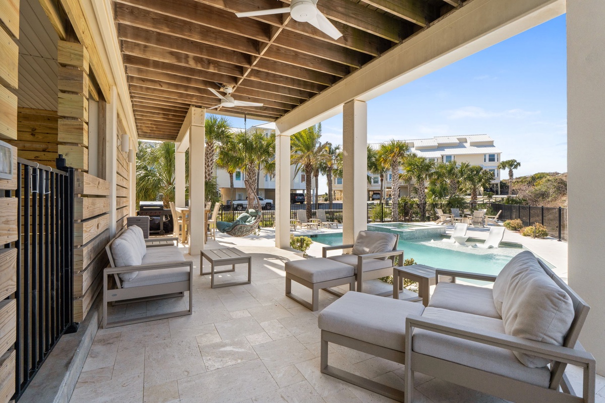 Relax in style on your covered terrace with plush seating overlooking the sparkling pool and tropical palms.