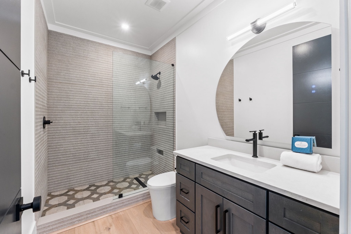 Your stylish private bathroom features a spacious walk-in shower with elegant tiling, modern fixtures, and fresh linens—ready for your arrival.