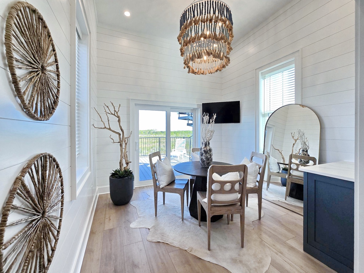 Step into your elegant dining space featuring coastal-inspired decor and stunning balcony views.