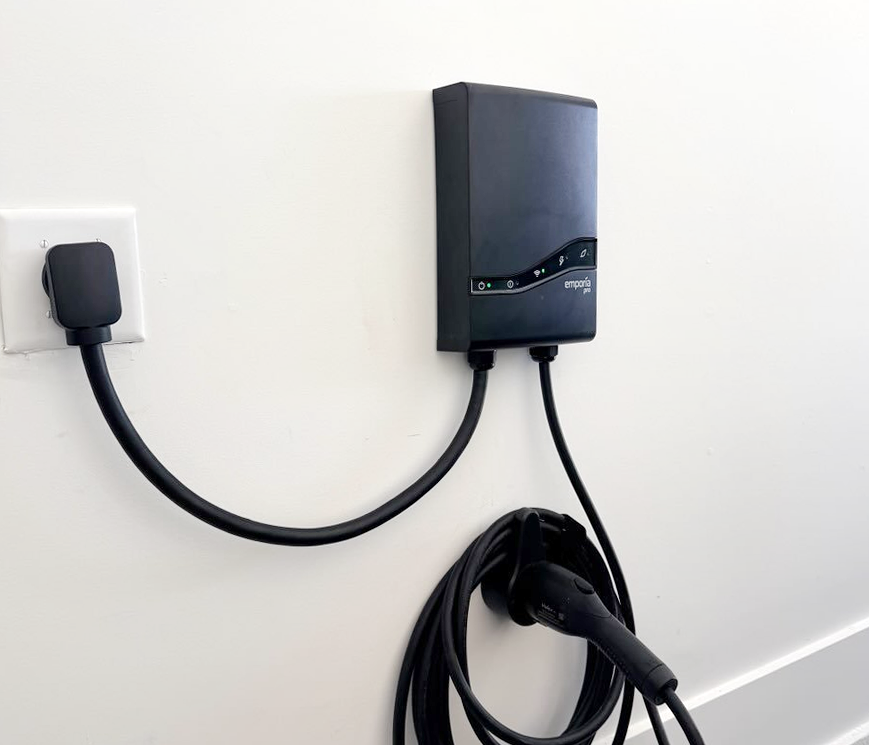 Modern electric vehicle charging station ready for your eco-friendly travels, conveniently mounted and easy to use during your stay.