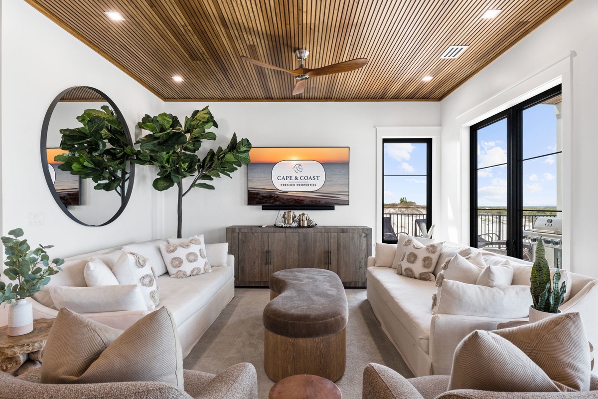 Settle into your inviting living room where warm wood tones and plush seating create the perfect gathering spot, while waterfront views through large windows promise peaceful moments any time of day.