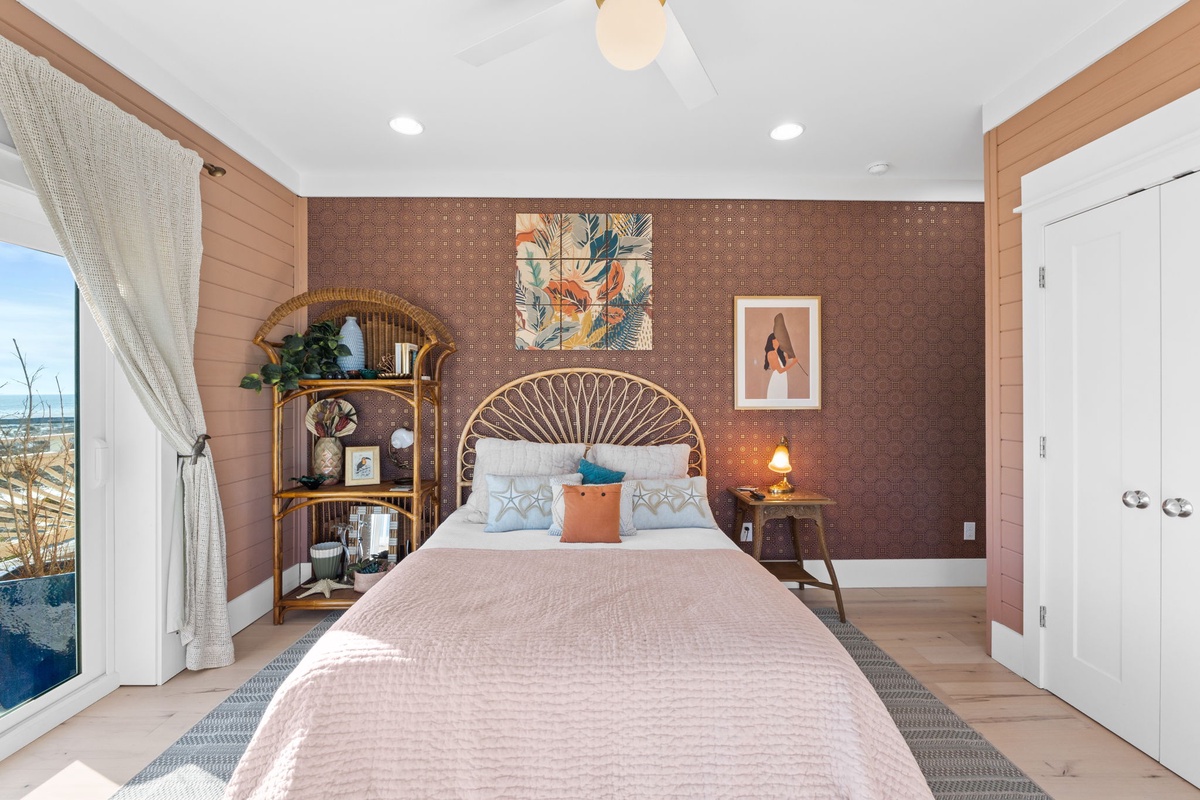 Your stylish bedroom features a wicker headboard, warm wood accents, and coastal artwork creating a serene retreat for restful nights.