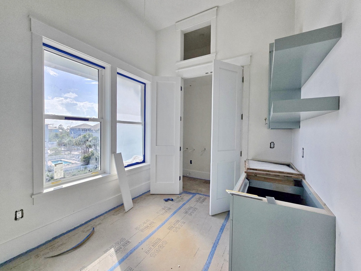 Bright kitchen with wide windows framing sunny skies and elevated coastal views—the perfect space for comfortable gatherings and memorable homecomings.