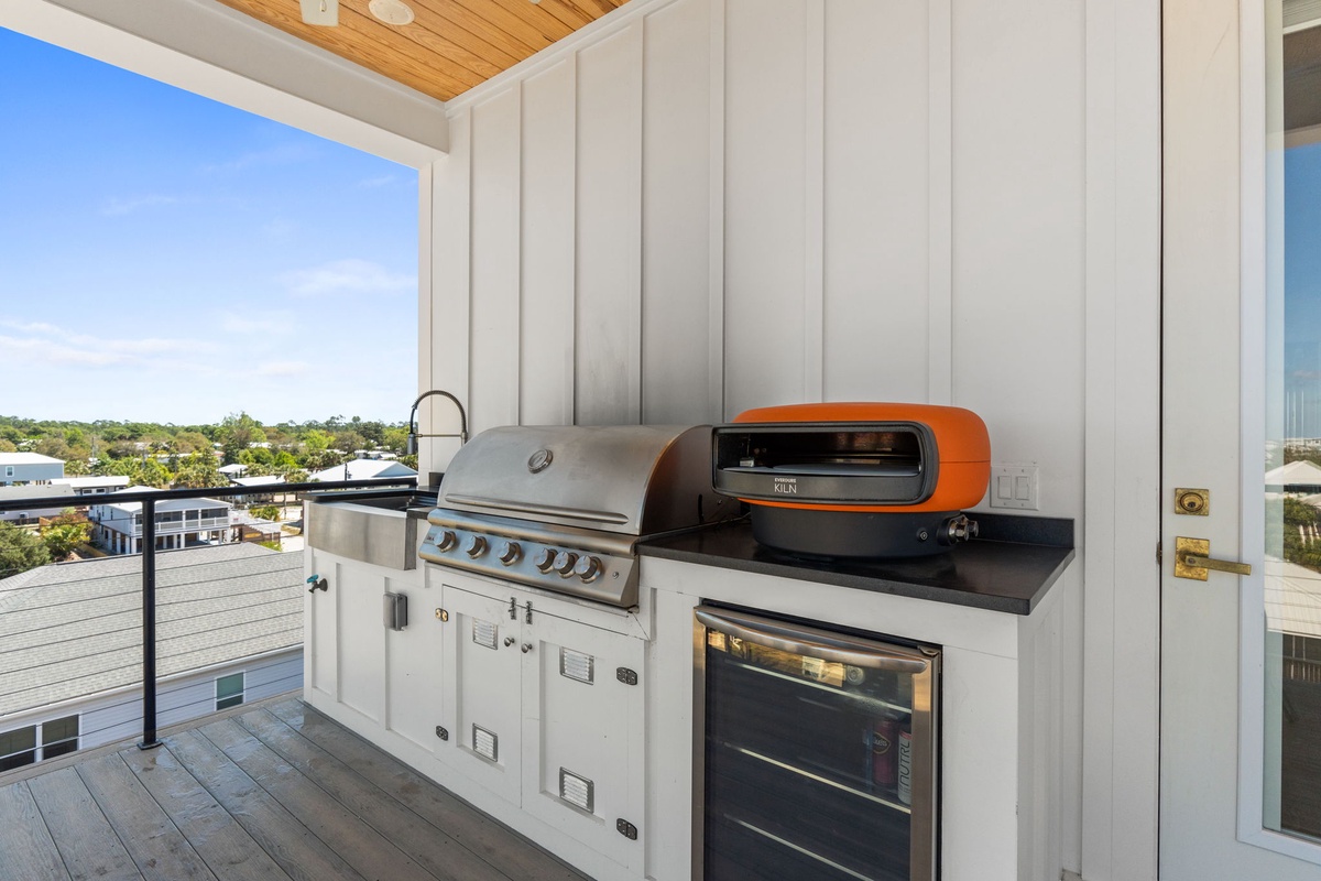 Your private rooftop kitchen awaits with premium grill, pizza oven, and wine fridge—perfect for memorable evenings above the city.