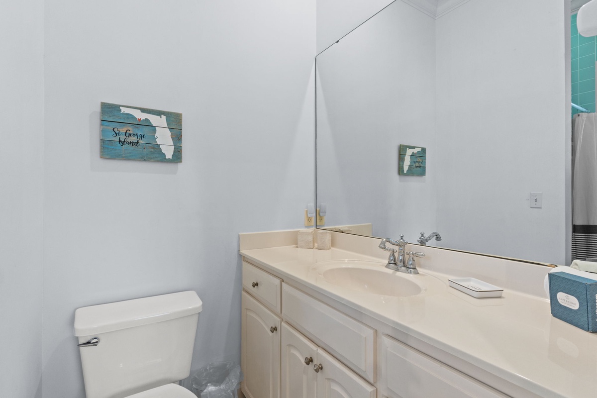 Your bright, well-appointed bathroom features a spacious vanity with ample storage and coastal charm touches.