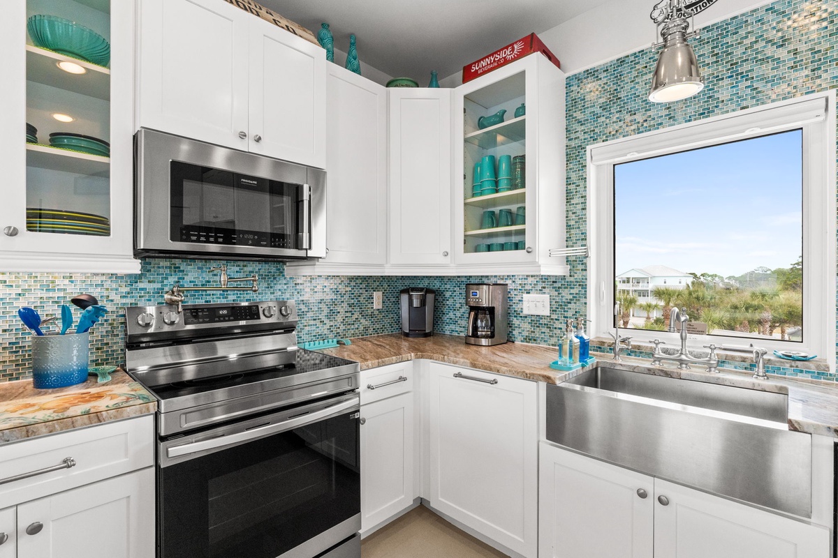 Your fully equipped kitchen features modern appliances and stunning turquoise tile backsplash, perfect for preparing meals while enjoying scenic views.