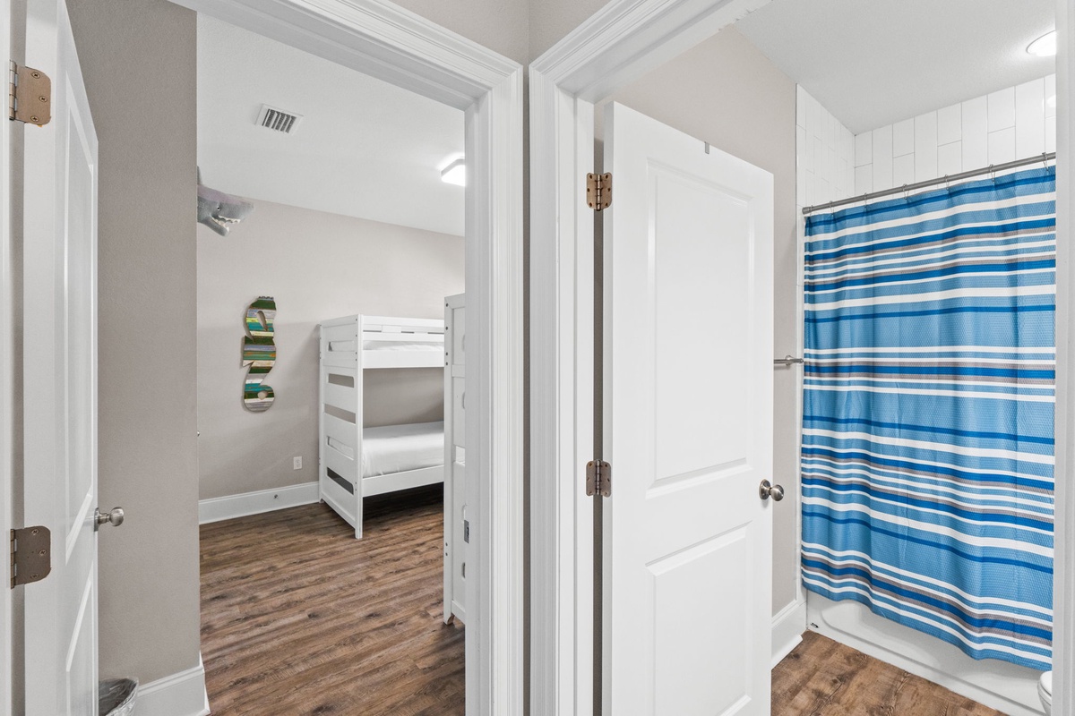 Your kids will love these cozy bunk beds, complete with their own bathroom featuring fresh blue striped touches.