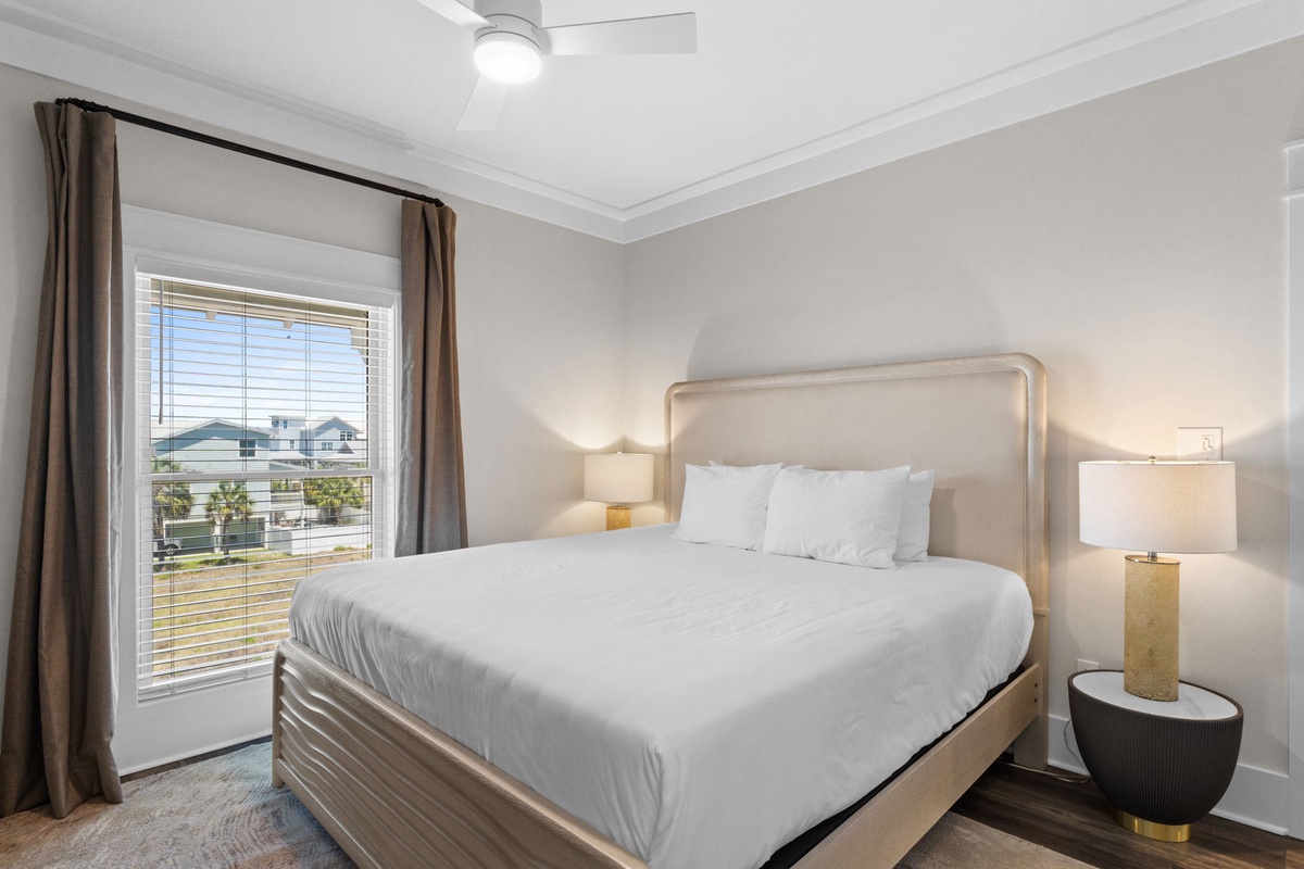 Your serene retreat awaits with crisp linens, warm bedside lighting, and a view framing the neighborhood beyond—designed for restful mornings and peaceful nights.