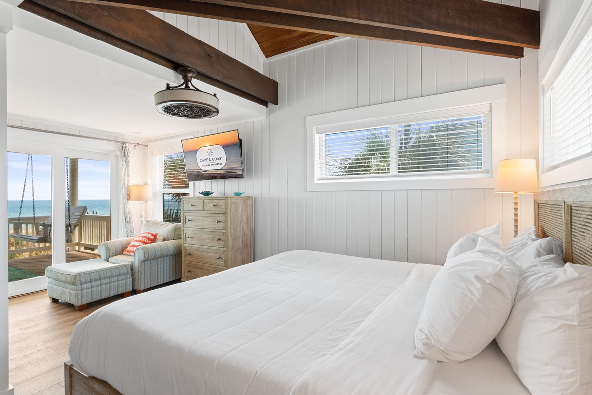 Wake up to coastal tranquility in your serene bedroom. Exposed beams and shiplap walls create a charming retreat, while your private balcony and genuine ocean view invite you to savor the sea breeze and morning light.