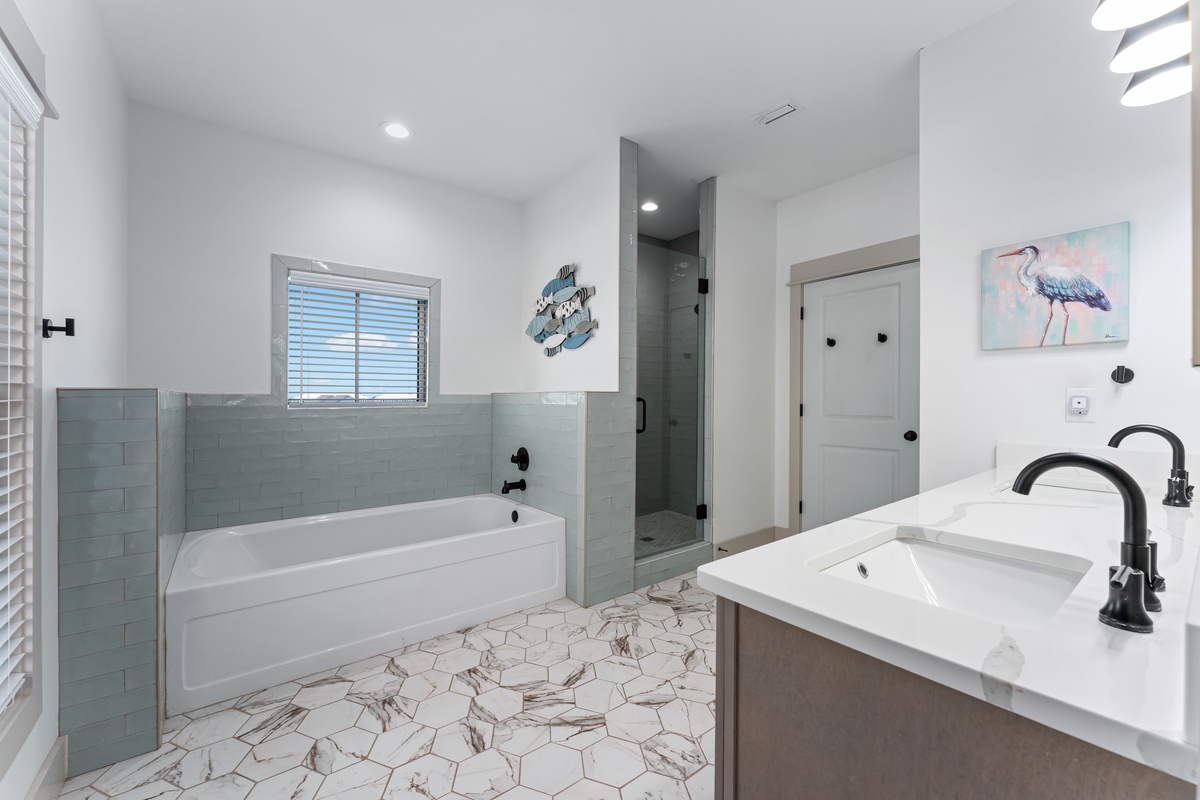 Unwind in your luxurious bathroom featuring marble countertops, soaking tub, and coastal-inspired decor for ultimate relaxation.