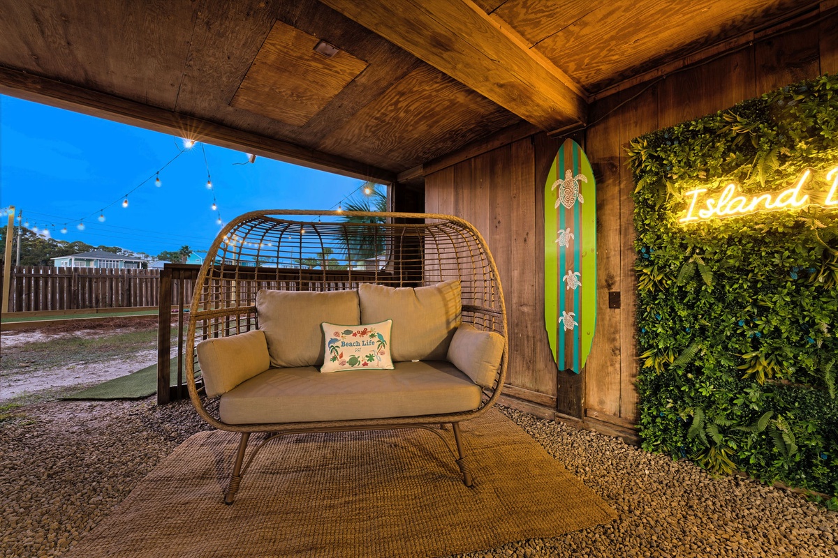 Unwind under the house, featuring a dreamy wicker egg chair and tropical vibes.