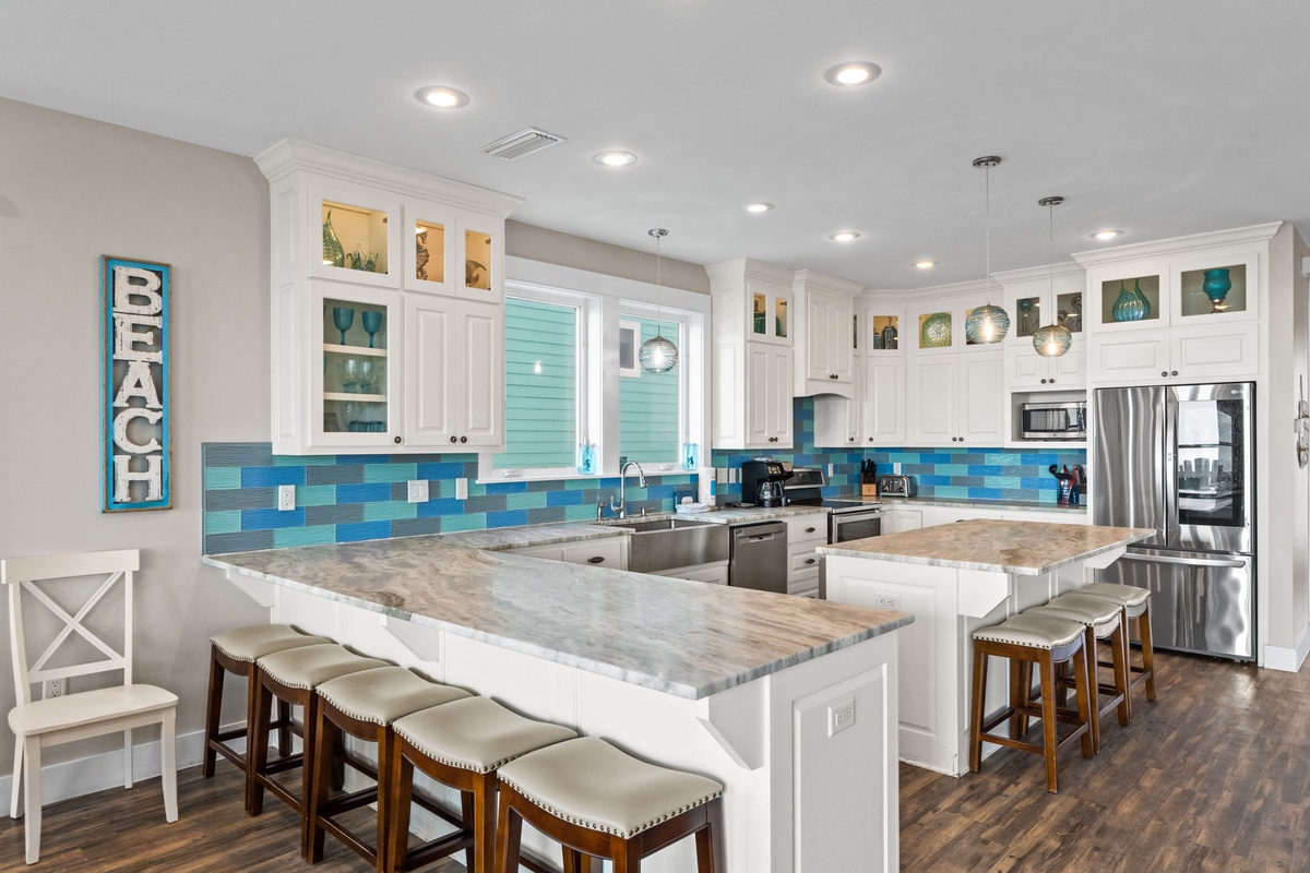Your dream kitchen awaits with coastal charm, featuring a spacious island for gathering and stunning ocean-inspired tile backsplash.