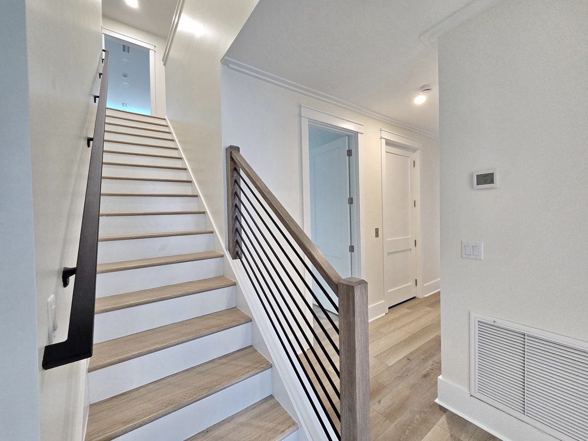 Your modern staircase welcomes you upstairs, while bright hallways with sleek fixtures create a fresh, contemporary feel throughout your stay.