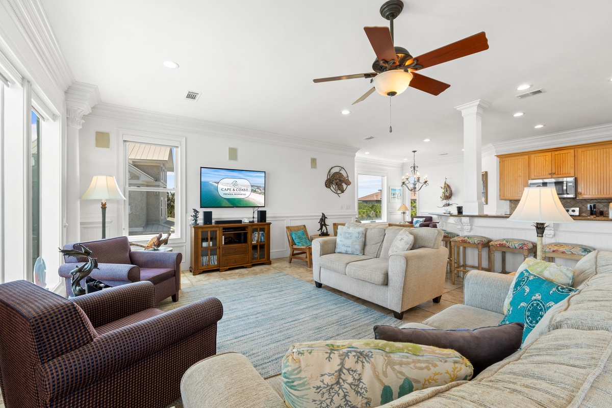 Settle into the bright, spacious living area where plush seating, coastal accents, and natural light create a welcoming retreat for your entire group to gather.