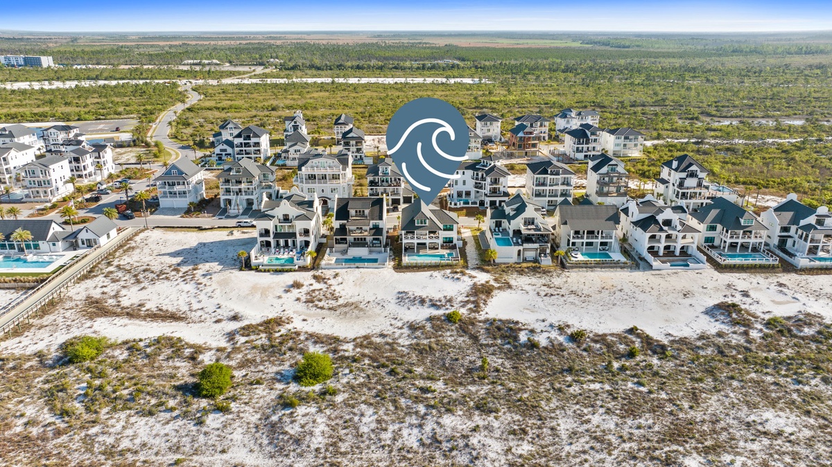 Stunning beachfront community with pristine white sand dunes and emerald coastal waters stretching to the horizon.