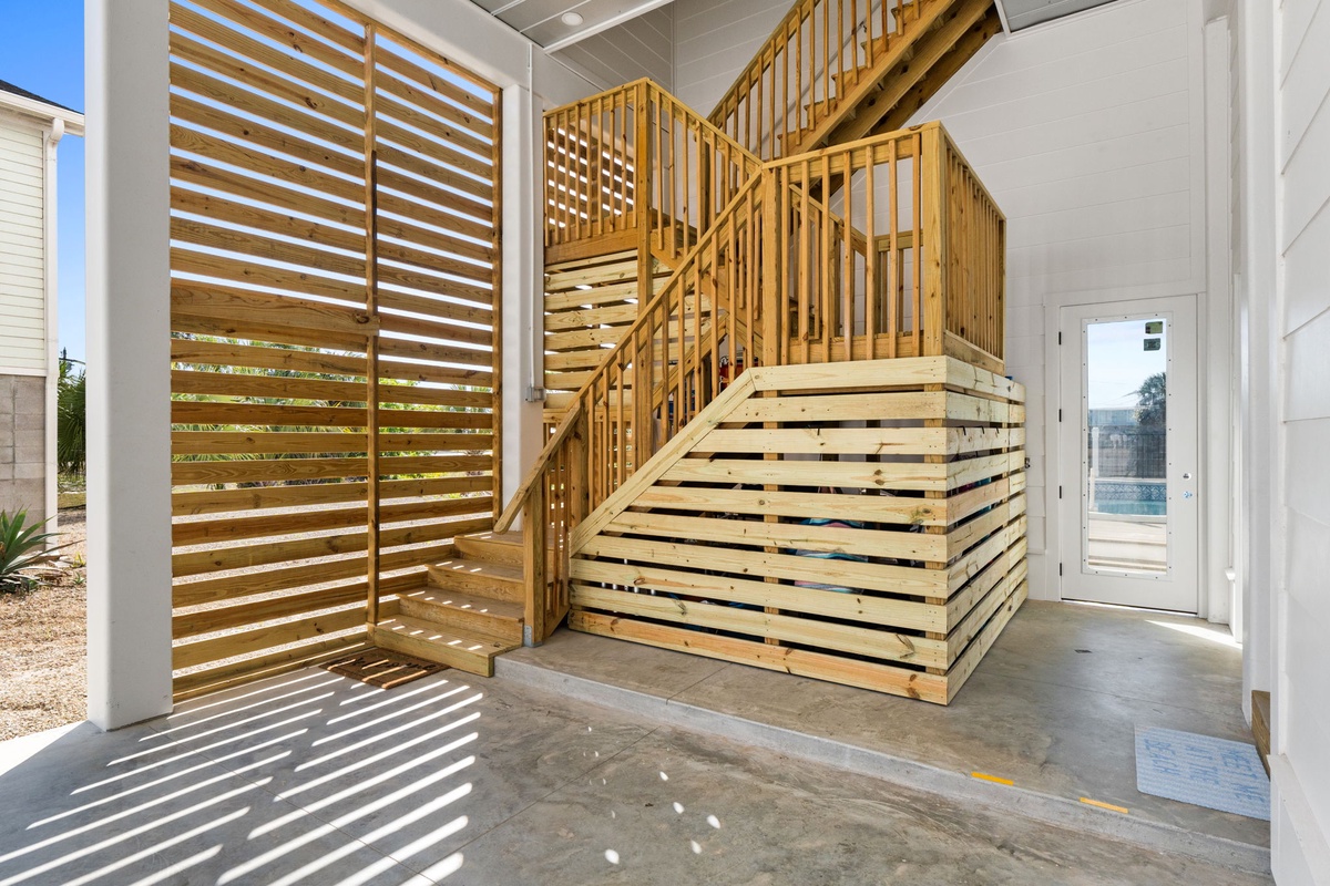 Step into a modern entryway with stunning natural light streaming through wooden slats, creating beautiful shadow patterns on polished concrete floors.
