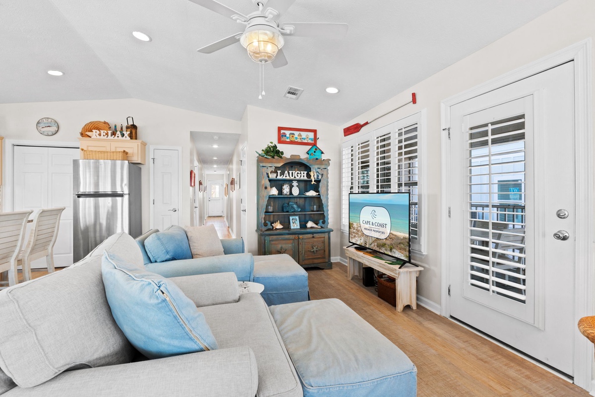 Sink into plush coastal-themed seating while you enjoy movie nights or catch up on your favorite shows in this bright, airy living space.