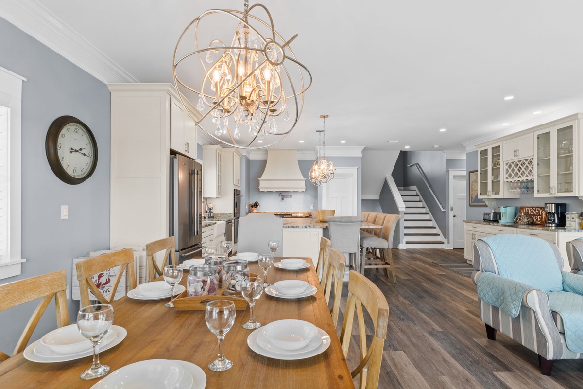 Your elegant dining space features a stunning chandelier, open kitchen, and cozy seating where memorable meals await.