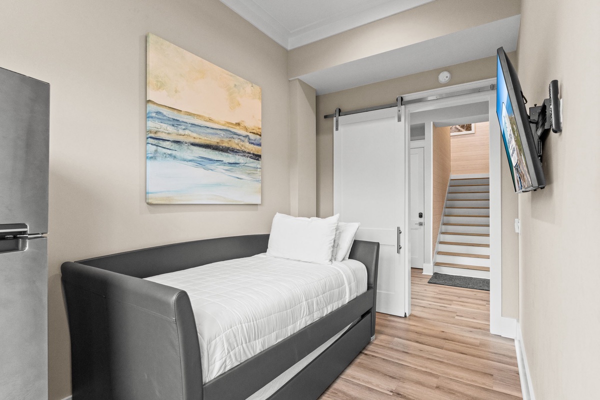 Sink into the sleek daybed after a day of exploring, with crisp linens and coastal-inspired art welcoming you home. The sliding barn door adds charm while the mounted TV keeps your favorite shows at your fingertips.