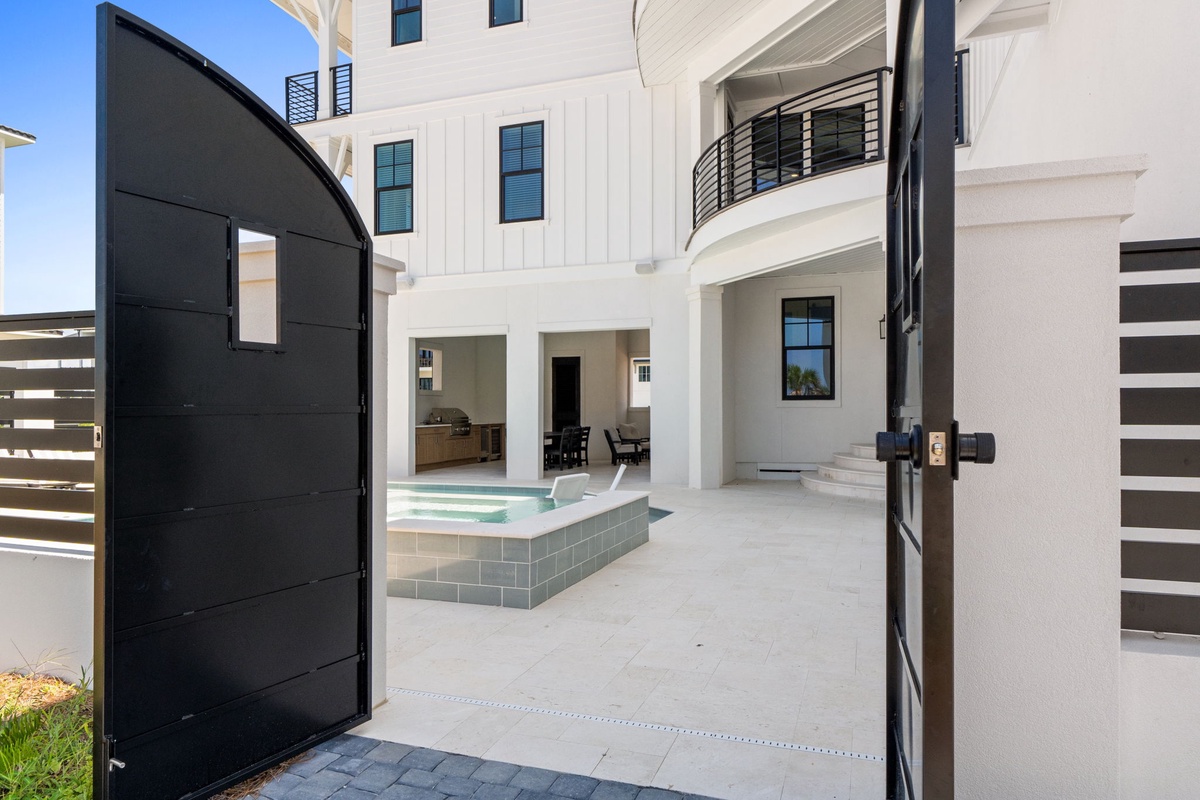 The property features a modern white exterior with a spacious interior courtyard centered around a luxury plunge pool.