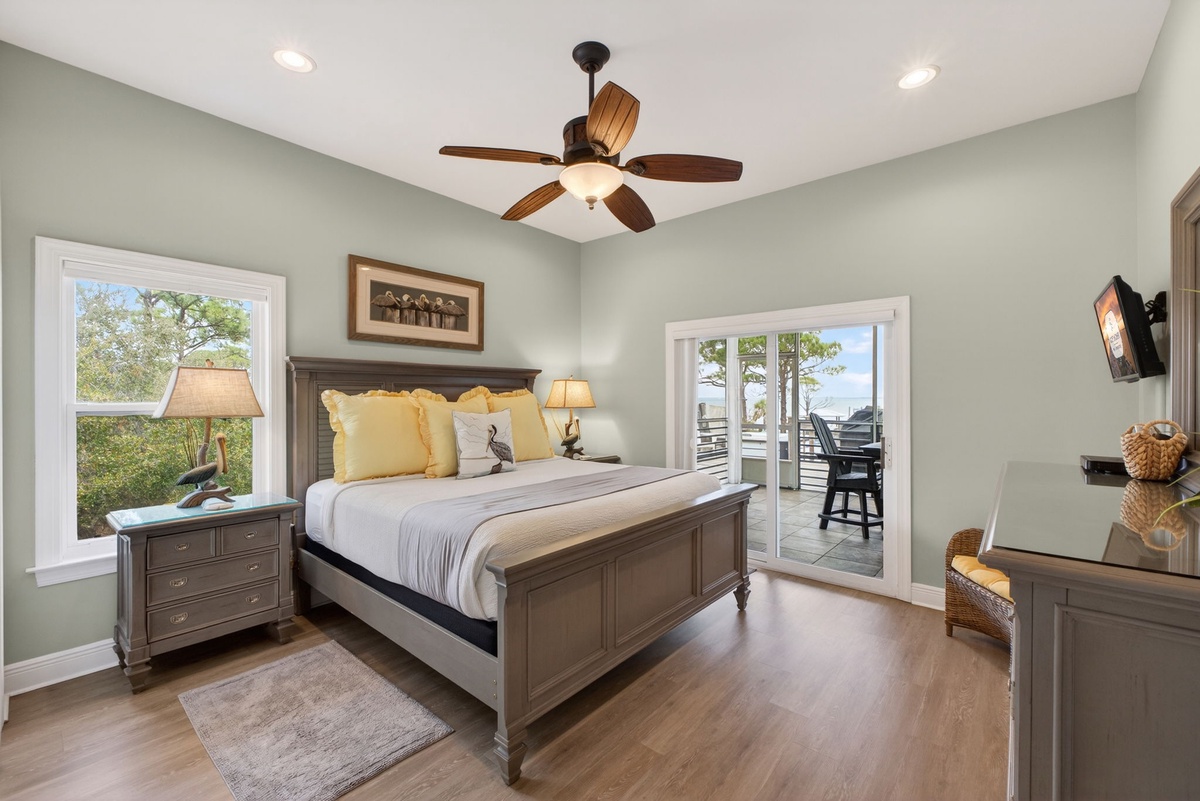 Rest in this serene bedroom with elegant furnishings, warm wood floors, and private balcony access for morning coffee.