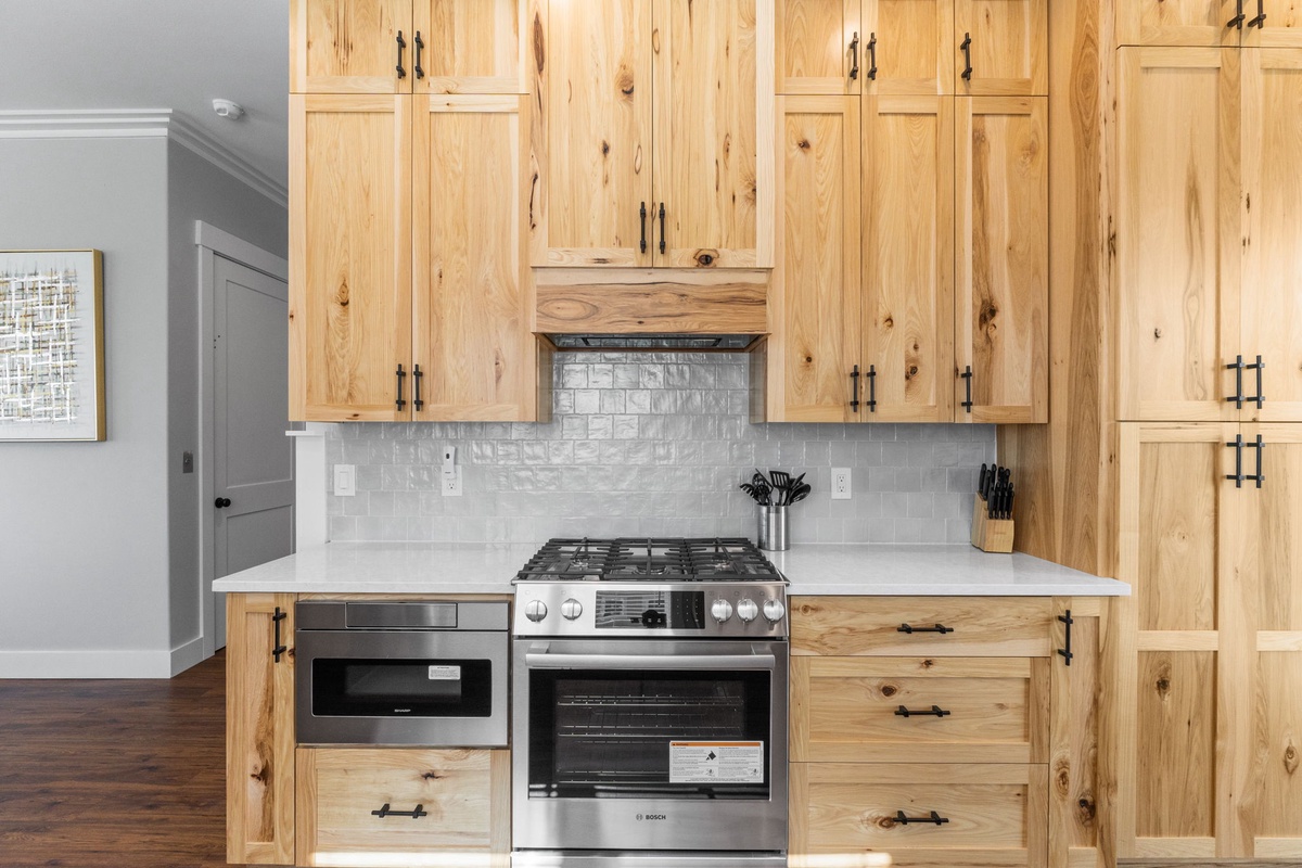 Cook your favorite meals in this beautifully appointed kitchen featuring warm wood cabinetry, modern stainless steel appliances, and elegant marble countertops.