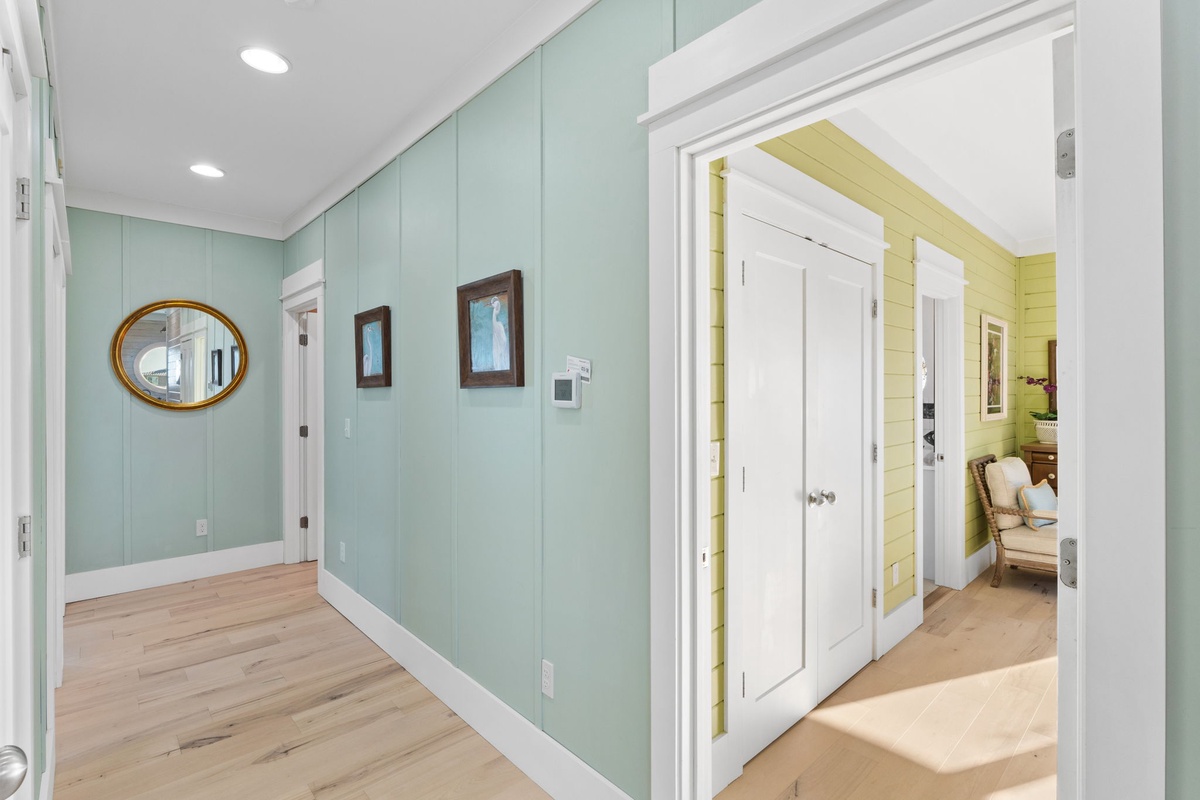 Step into your welcoming entryway with soothing seafoam walls and warm wood floors that flow throughout your coastal retreat.