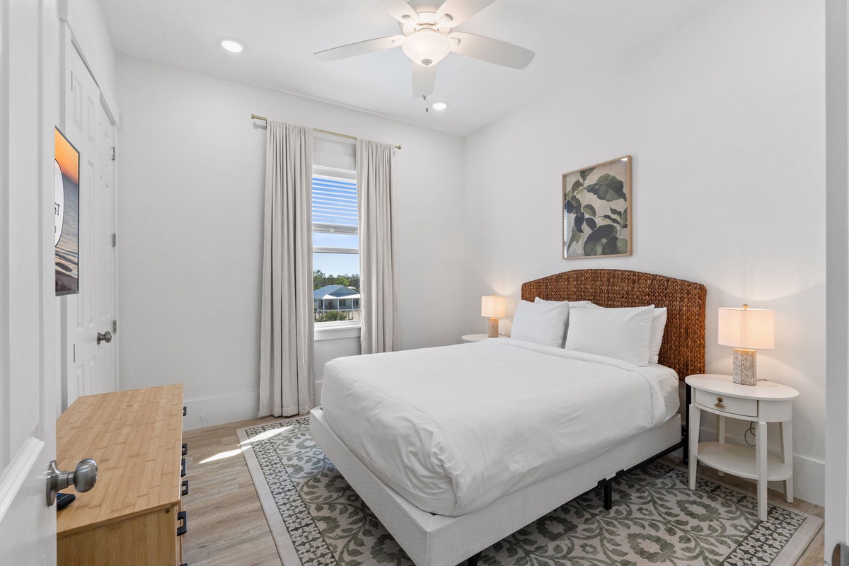Unwind in your serene bedroom featuring crisp linens, a woven headboard, and gentle natural light filtering through soft curtains.