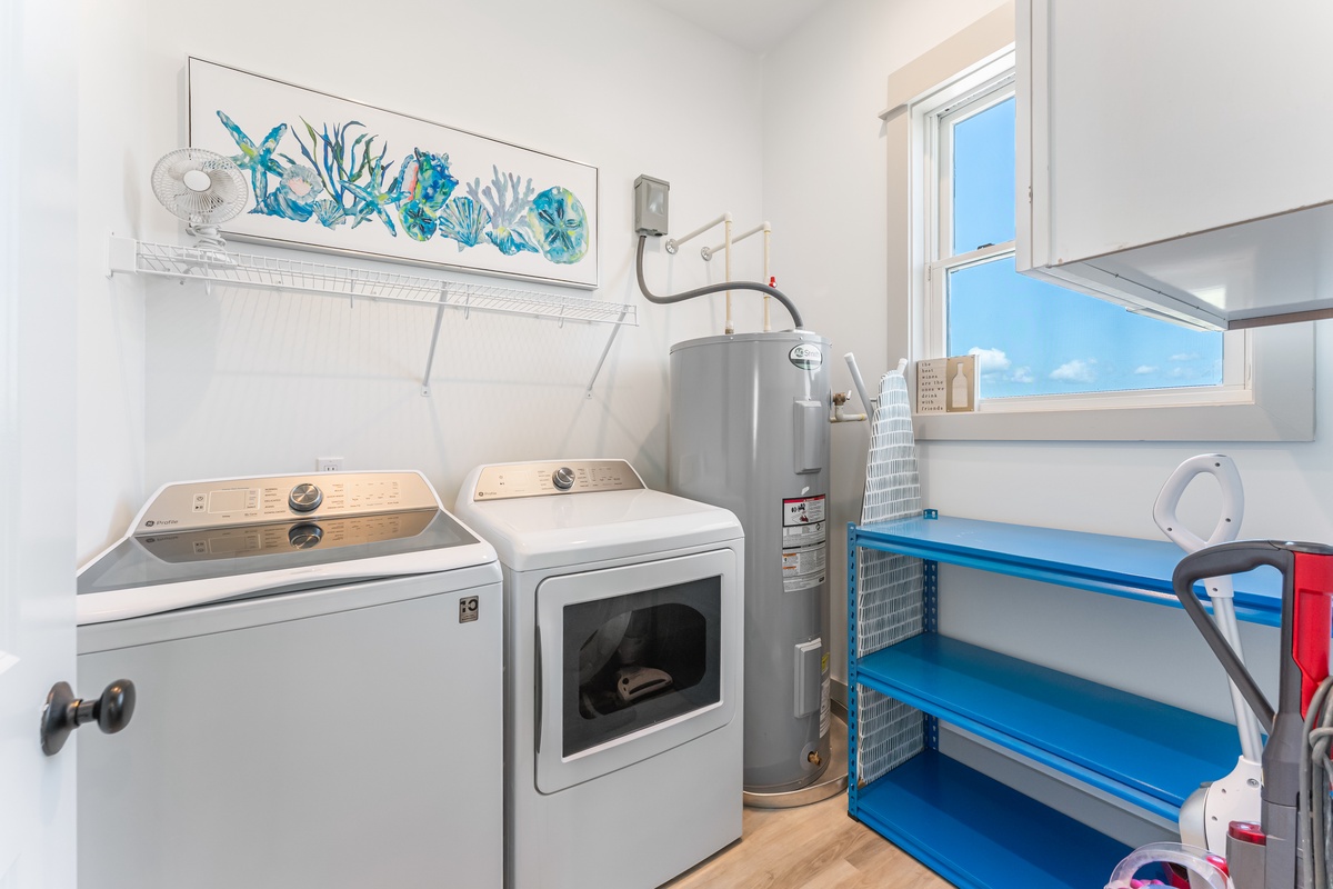 Your dedicated laundry room keeps your clothes fresh throughout your stay, with coastal-themed artwork adding charm to this practical space.
