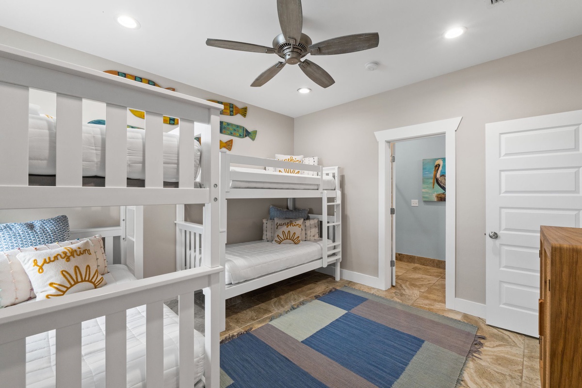 Two cozy bunk beds await, perfect for your kids or group. The cheerful sunshine pillows and coastal fish accents add a playful, beachy vibe to your stay.