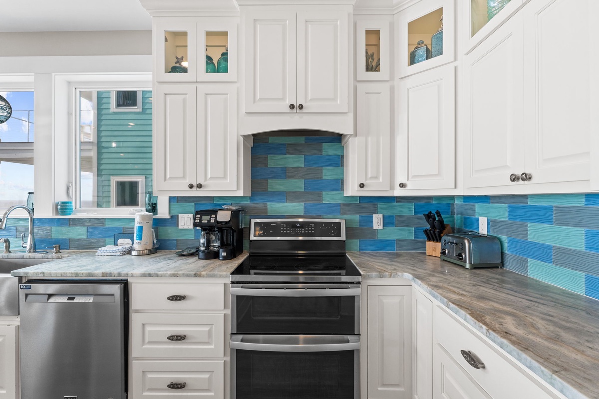 Your fully equipped kitchen features stunning ocean-inspired blue tile backsplash and modern appliances for memorable vacation meals.