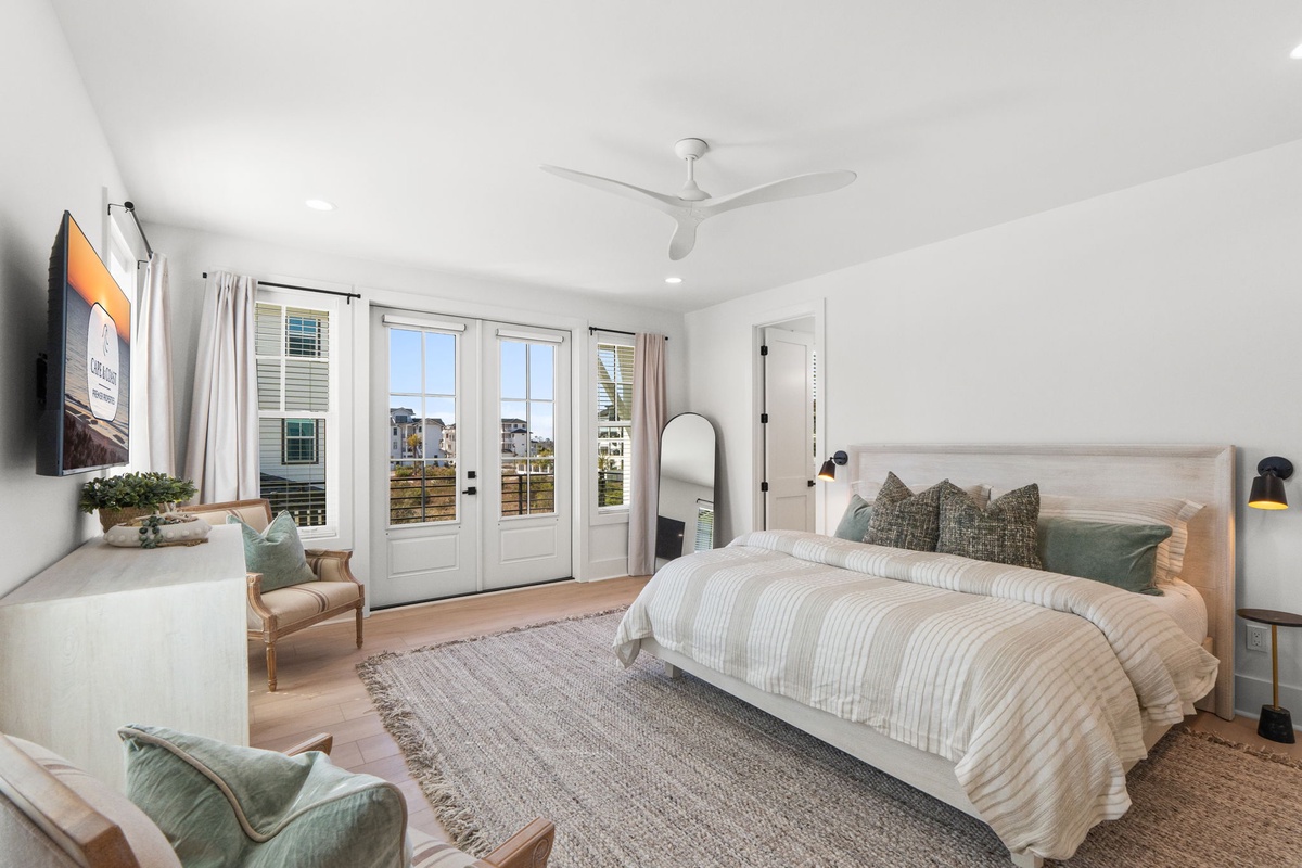Unwind in your serene bedroom with crisp linens, coastal touches, and French doors opening to your private balcony.