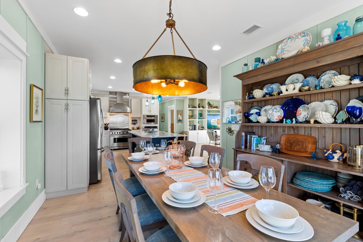 Your elegant dining space features a beautifully set table for eight, complete with charming dishware displayed on rustic shelving.
