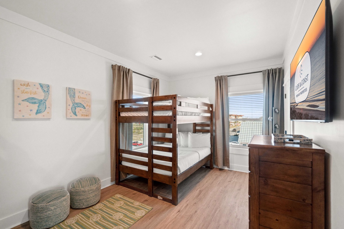 Your kids will love this cozy bunk bed room with playful sea turtle art and comfy floor cushions for movie nights.