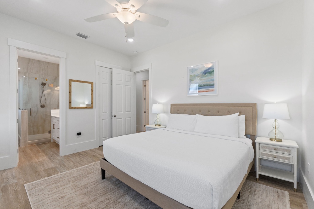 Sink into crisp white linens and drift off under your private ceiling fan in this serene master bedroom with ensuite bathroom.
