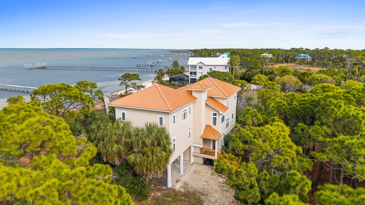 Elevated waterfront retreat surrounded by lush coastal forest with private dock access and stunning bay views.