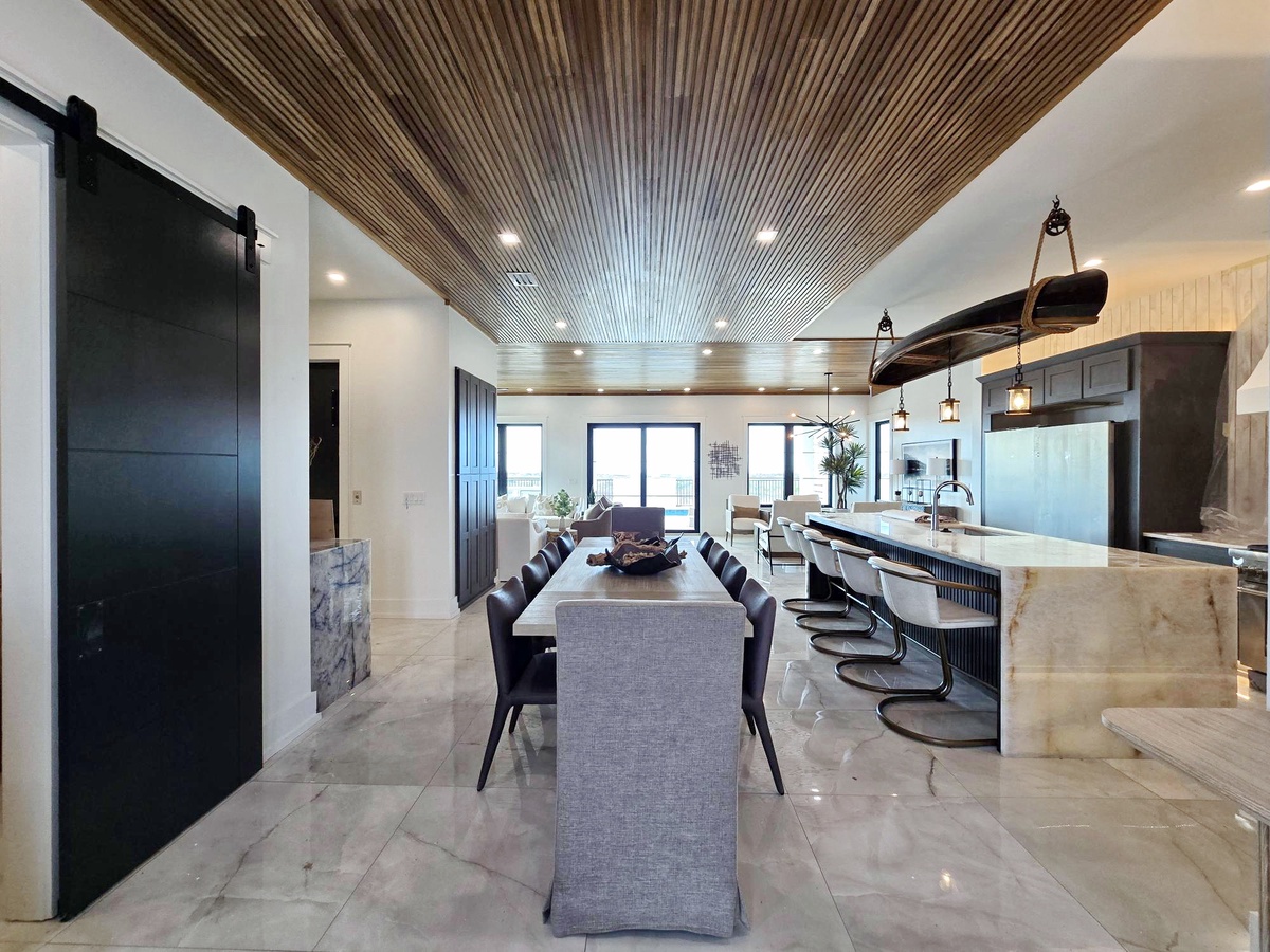 Your open-concept kitchen flows seamlessly into dining space, featuring stunning wood ceiling details and modern finishes perfect for gathering.