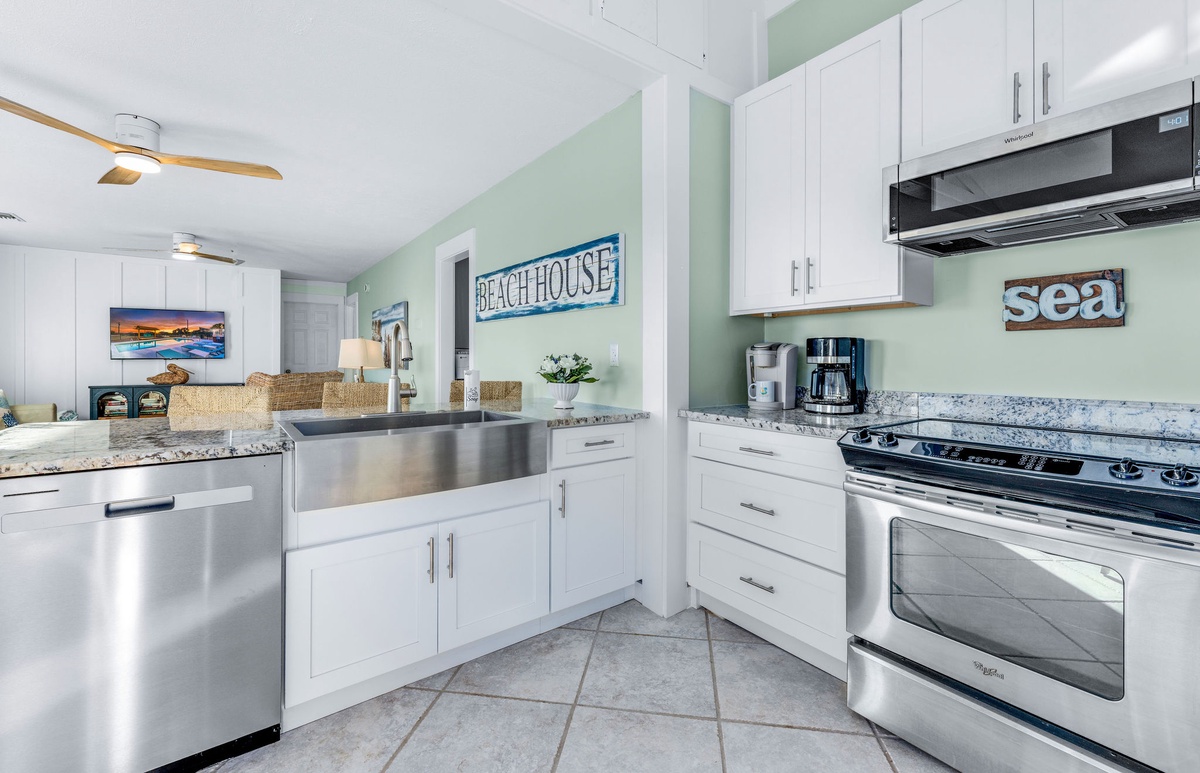 Your fully equipped kitchen features granite counters, stainless appliances, and coastal charm with sea-inspired decor throughout.