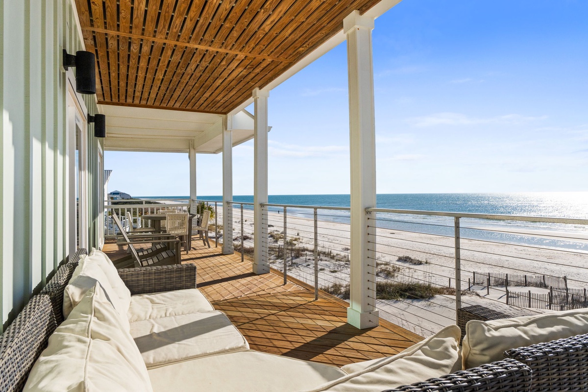 Sink into plush oceanfront seating where warm wood and cool sea breezes create your perfect coastal retreat.