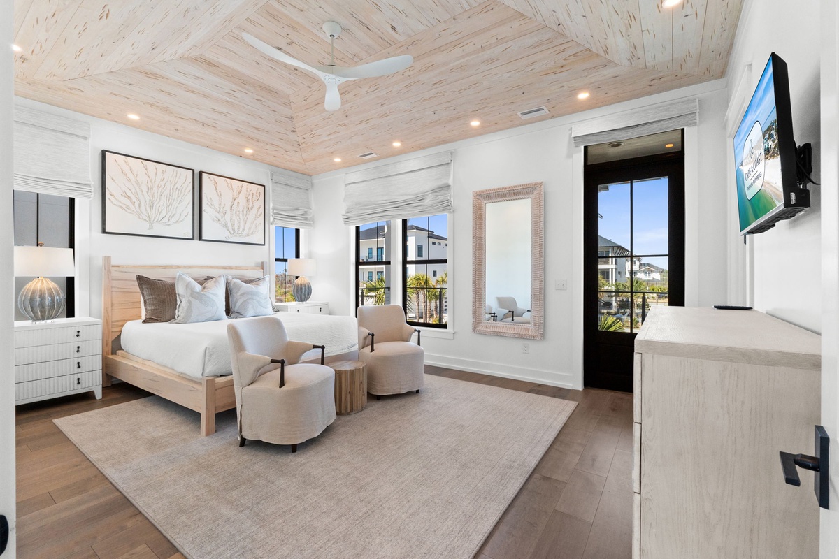Relax in your luxurious bedroom featuring soaring wood ceilings, elegant furnishings, and French doors opening to your private outdoor space.