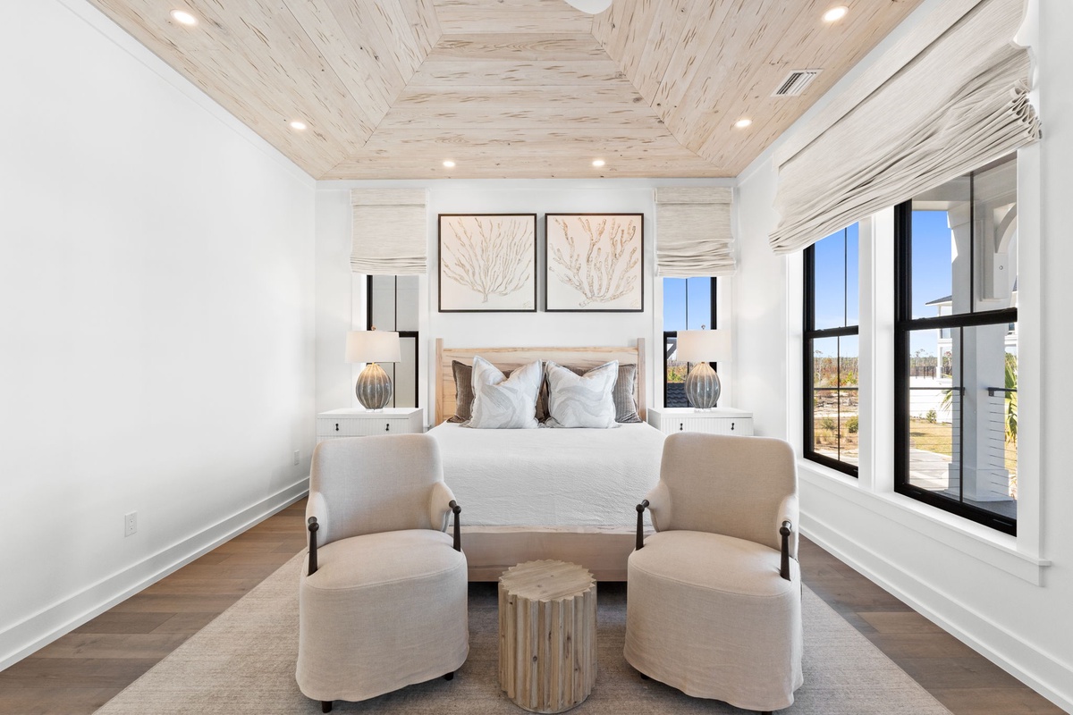 Sink into plush comfort in your elegantly appointed bedroom, where natural wood ceiling beams and soft linens create the perfect sanctuary for restful nights.