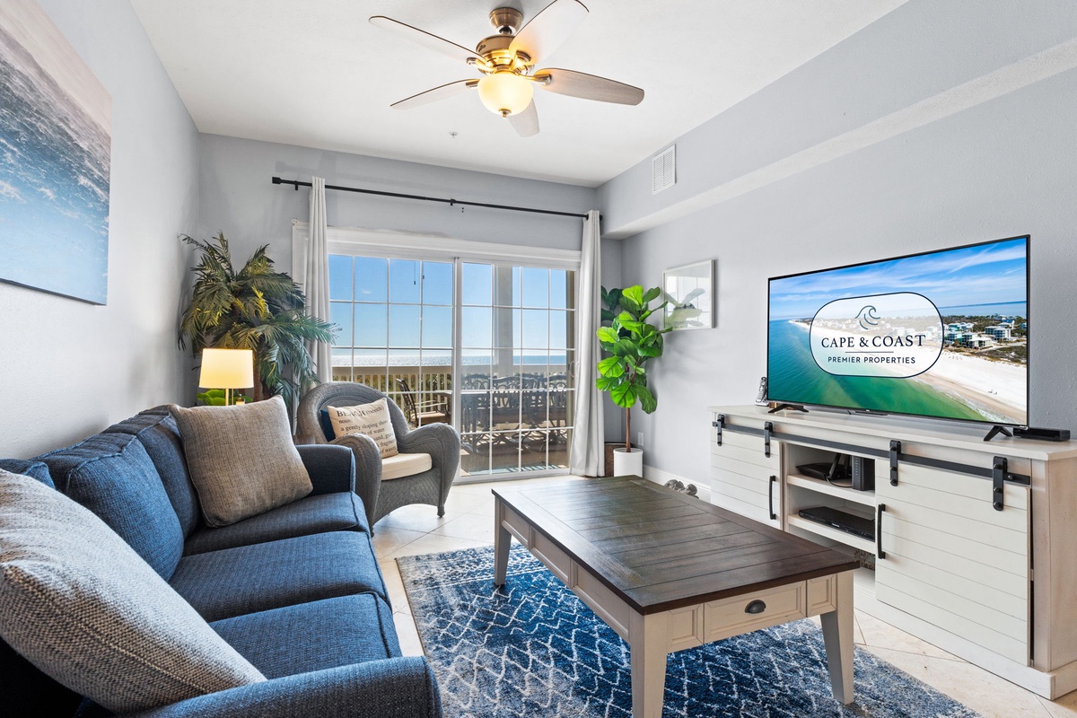 Your bright living space features comfy seating and a large TV, with stunning ocean views through glass doors leading to your private balcony.