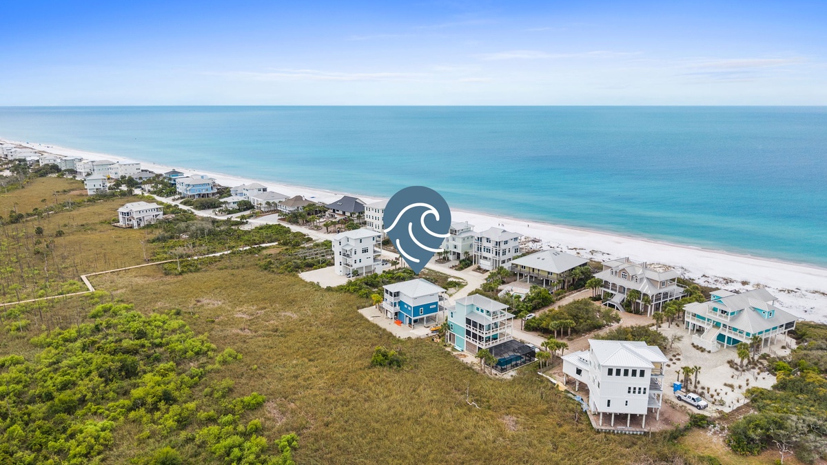 Stunning beachfront community with pristine white sand beach and crystal-clear turquoise waters stretching to the horizon.