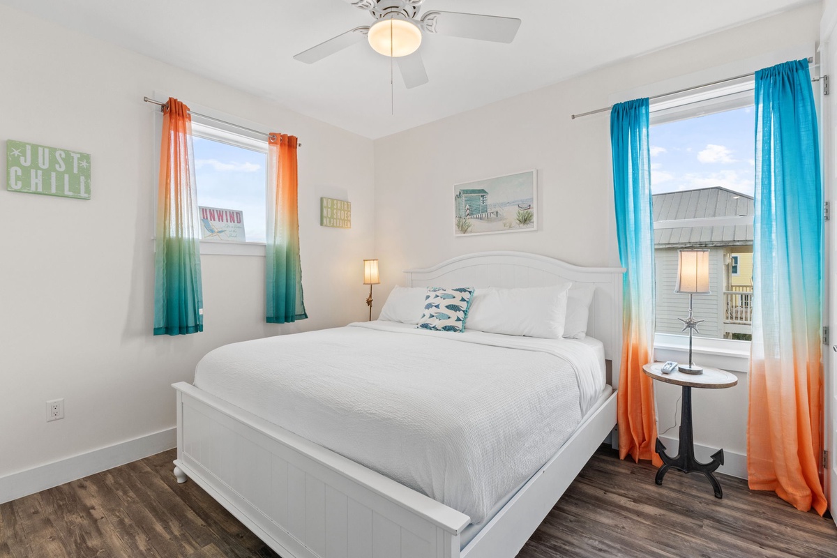 Drift off in your cheerful coastal bedroom, where vibrant ombre curtains frame peaceful views and crisp linens invite restful nights.