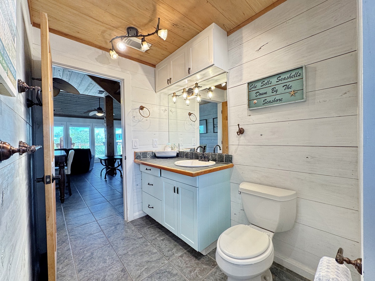 Unwind in this coastal-themed bathroom with beach-inspired details, granite counters, and warm wood accents that create your perfect seaside retreat.