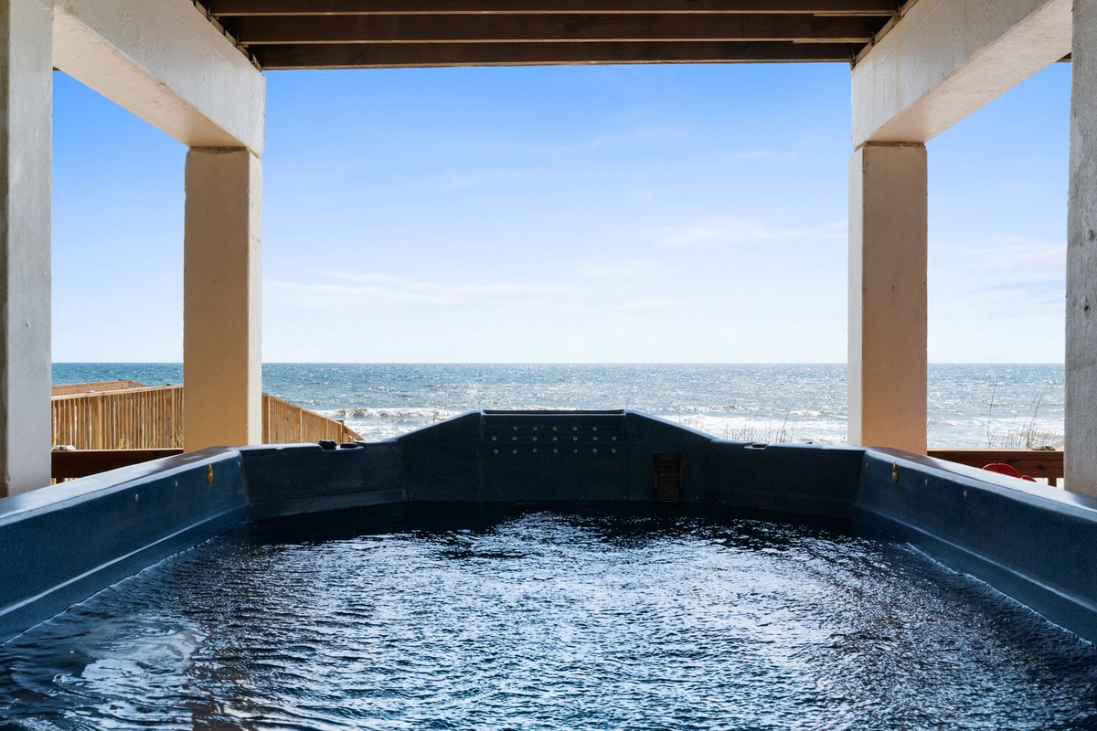 A covered hot tub overlooks the pristine coastline, offering a tranquil spot to soak while enjoying uninterrupted ocean views and gentle sea breezes.