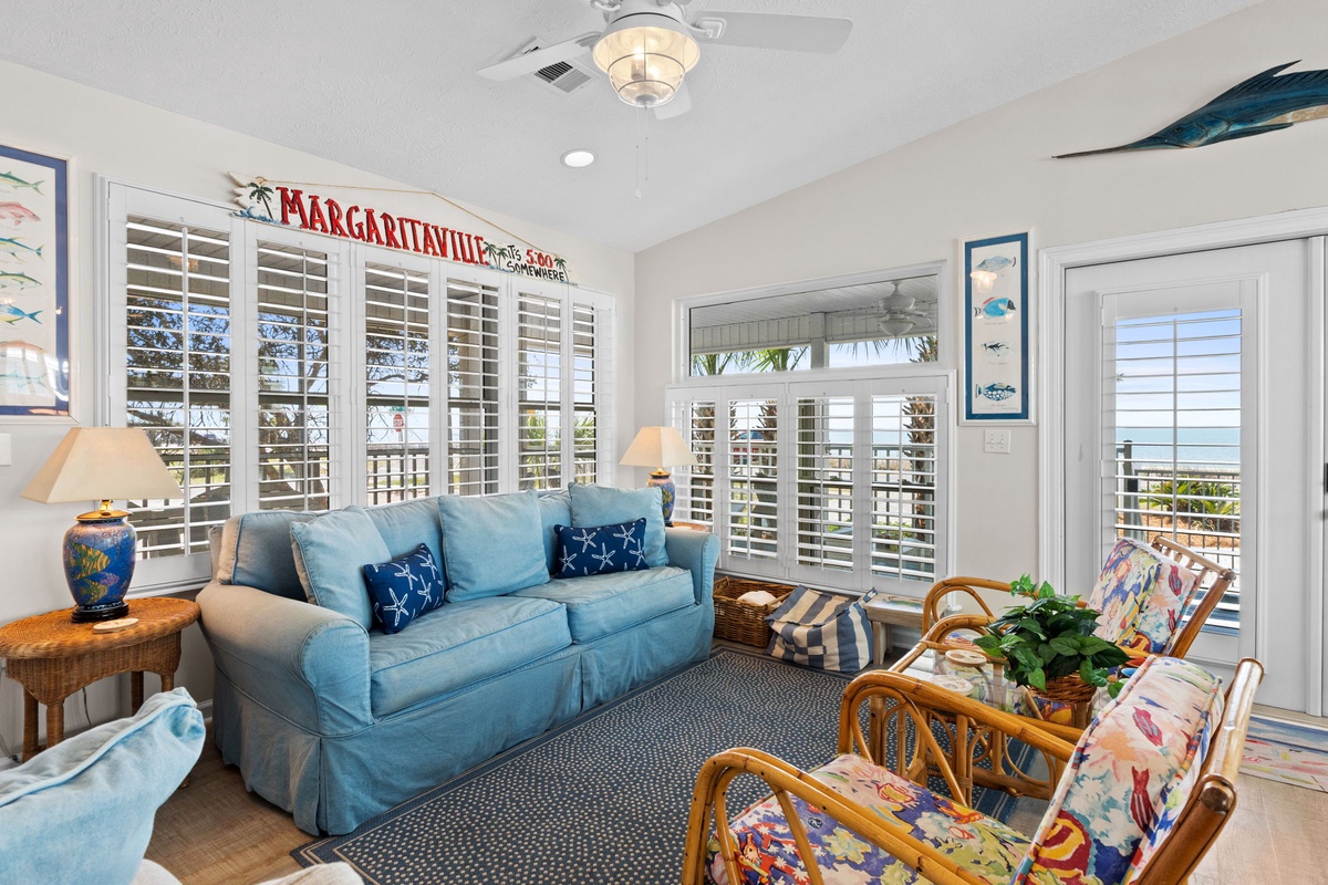 Sink into this coastal living room where ocean breezes flow through plantation shutters and tropical décor creates your perfect beach retreat.