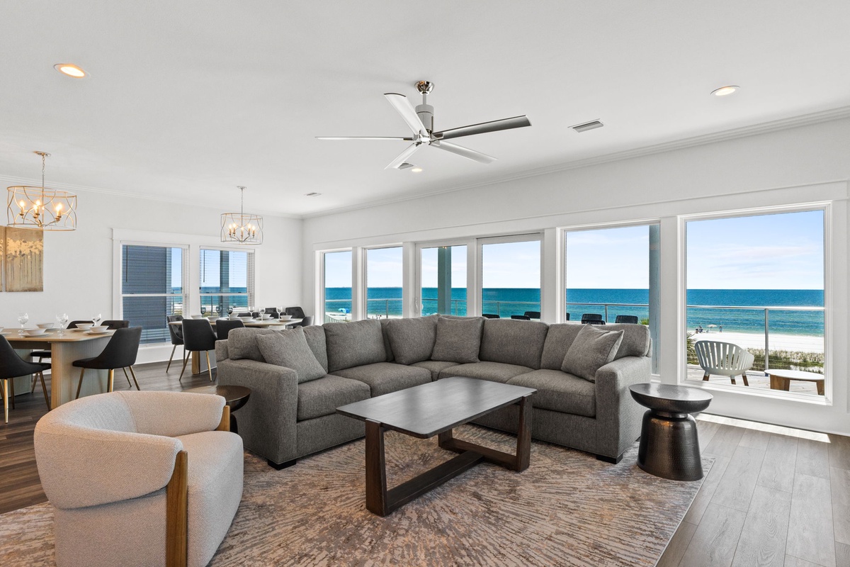 Relax in your spacious living area where floor-to-ceiling windows frame stunning ocean views, creating the perfect backdrop for your coastal getaway.