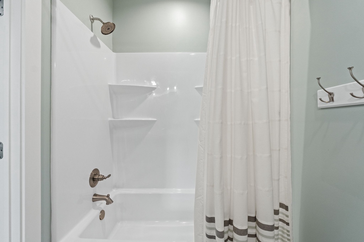 A spotless tub and shower space ready for your refreshing morning rinse or soothing evening soak after exploring the area.