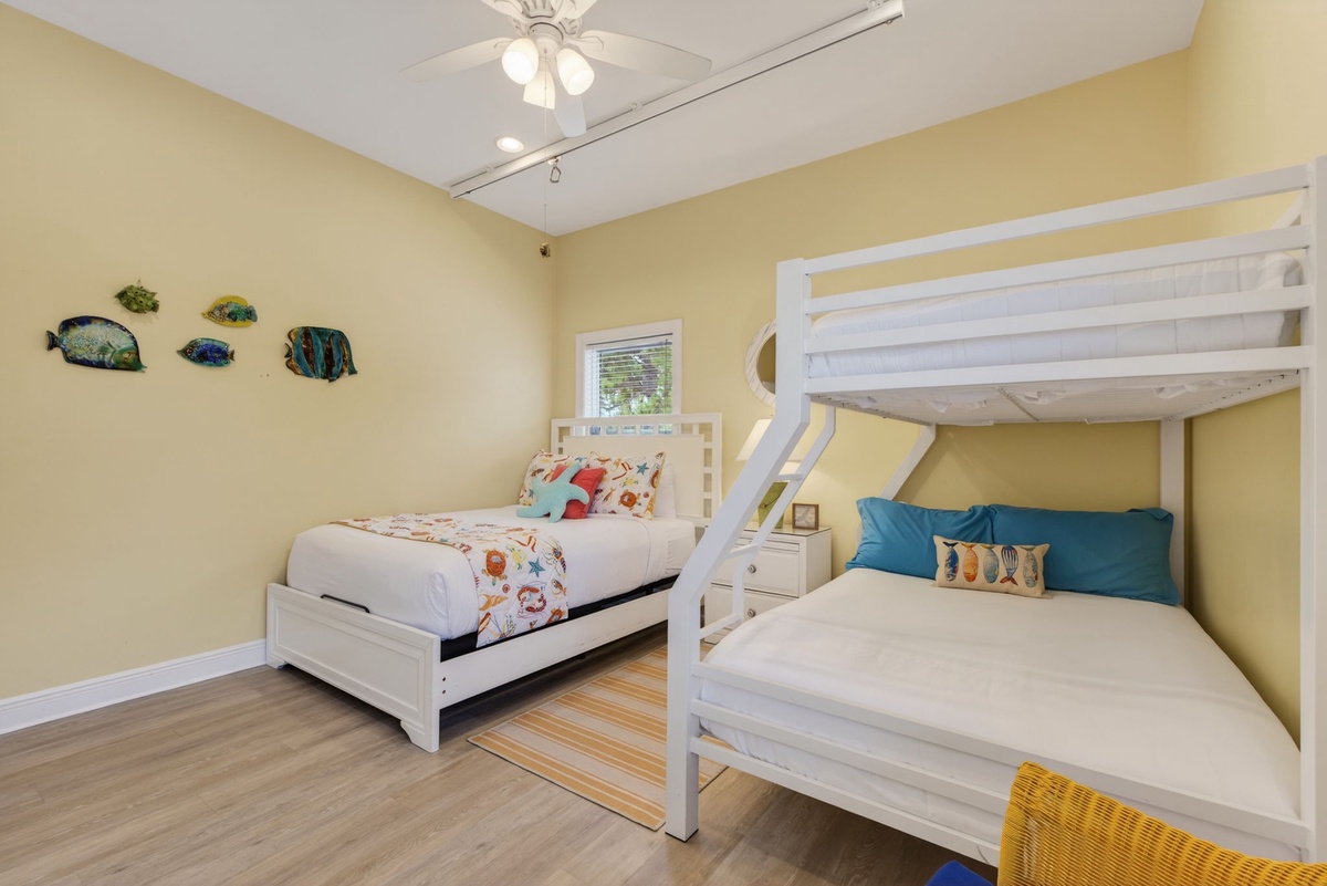 Your kids will love this cheerful bedroom with colorful fish wall art, comfortable bunk beds, and plenty of space to play.